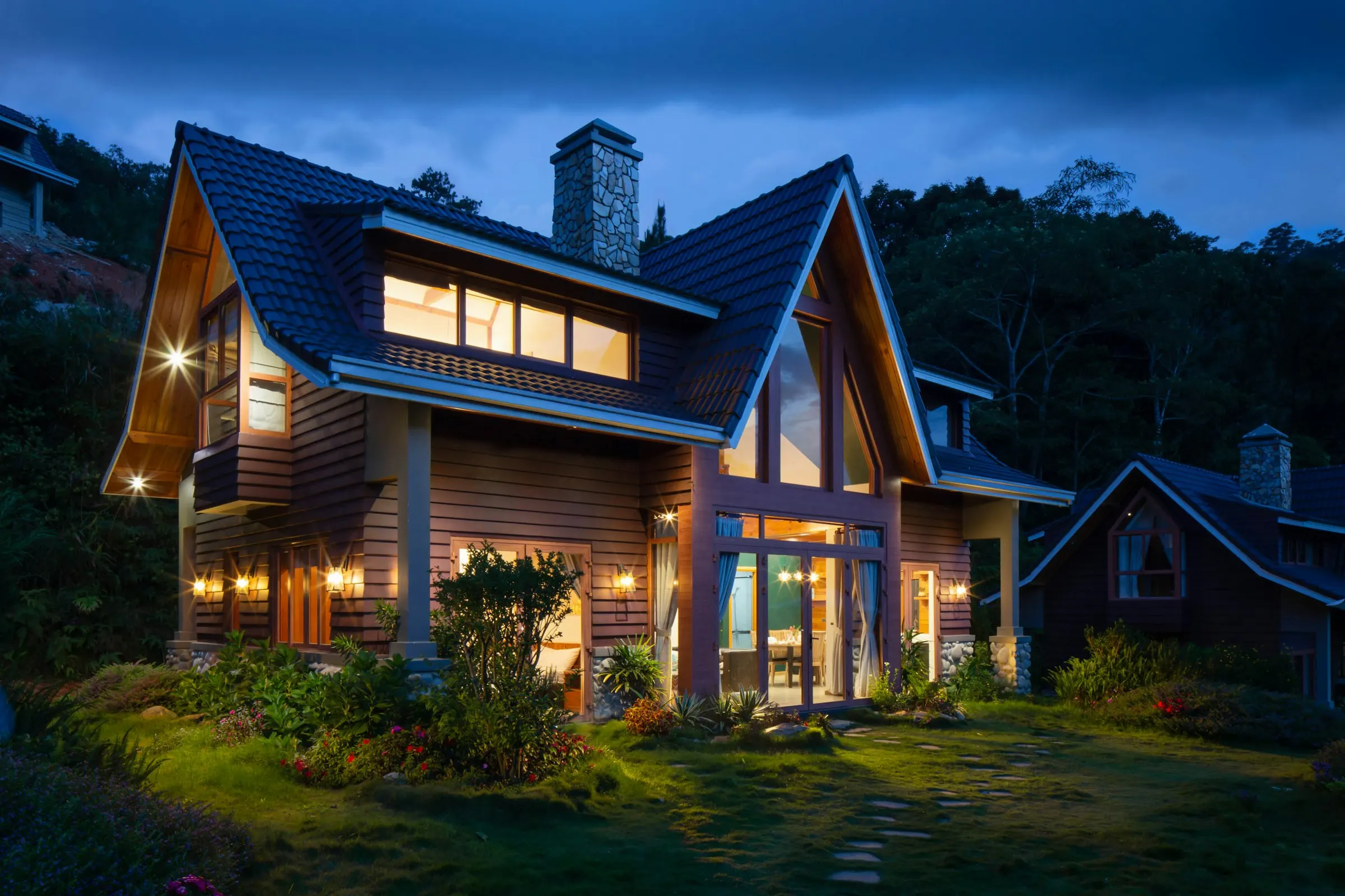 A gabled house and garden in evening light.